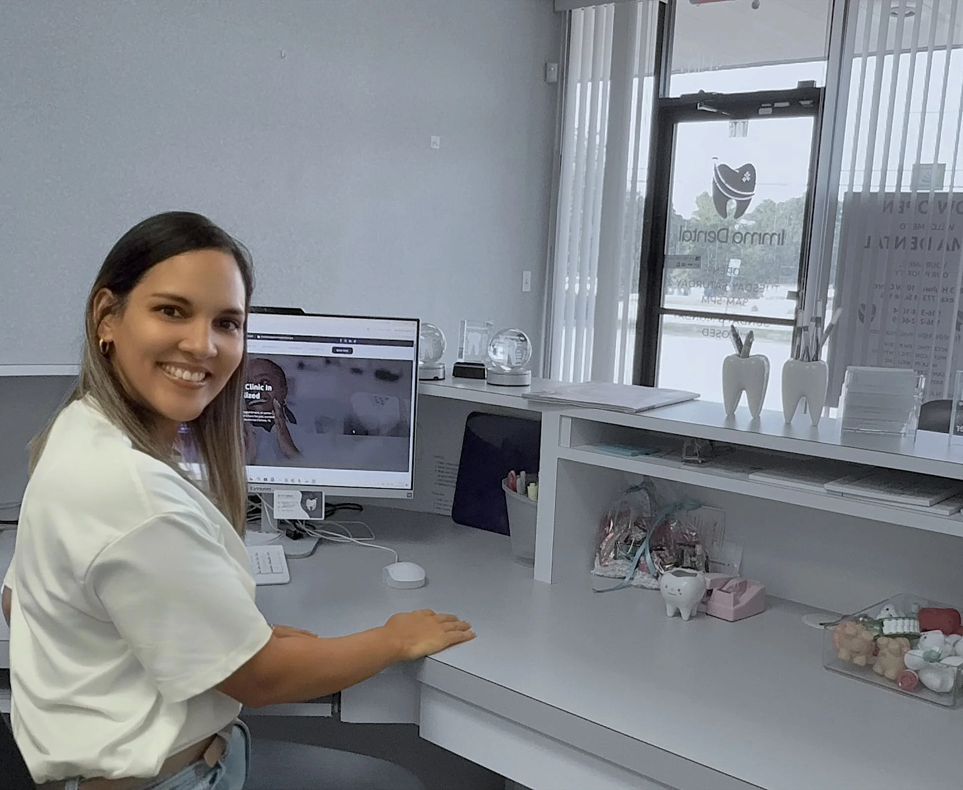 A smiling team member at the Imma Dental reception desk